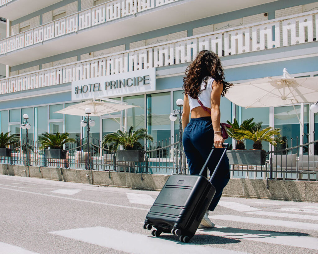 girl with suitcase reaching the prince hotel, we see the facade of the hotel