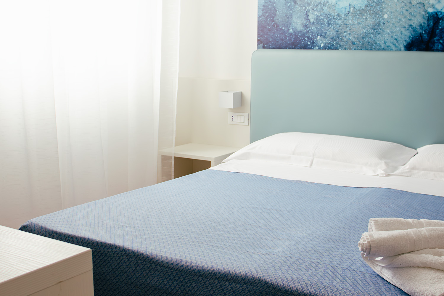 letto matrimoniale della camera doppia economy, vediamo sopra alle lenzuola gli asciugamani puliti e arrotolati