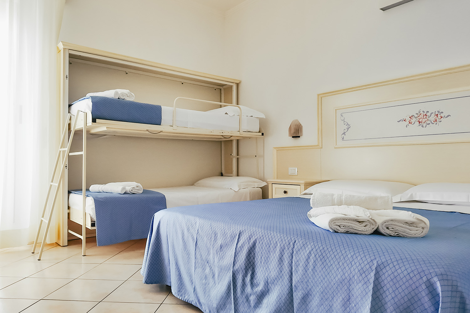 letto matrimoniale e il letto a castello della camera family economy, vediamo sopra alle lenzuola gli asciugamani puliti e arrotolati