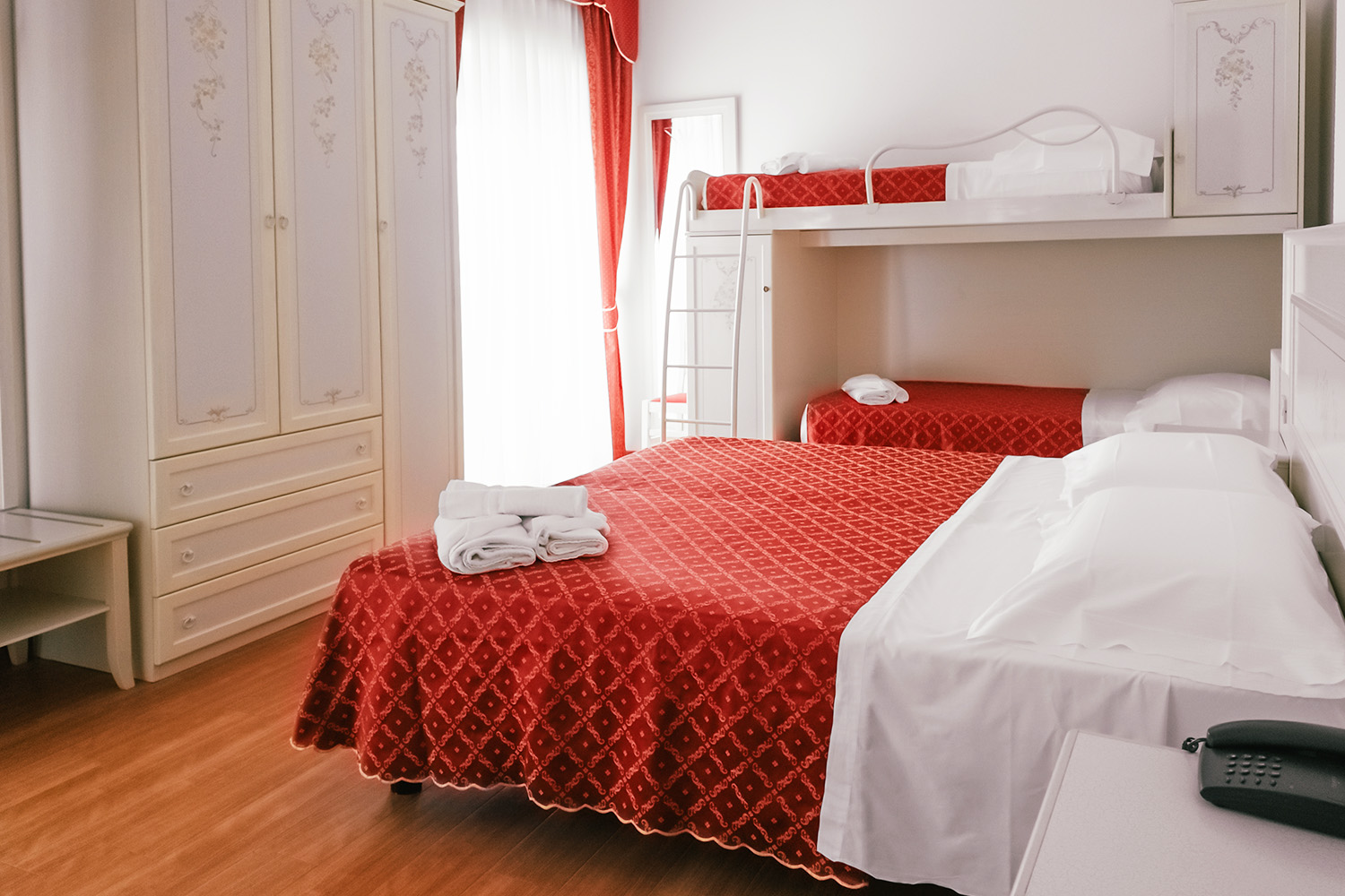 letto matrimoniale e letto a castello con lenzuola rosse e bianche